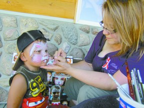 Deanne Jackson, a Rochfort Bridge artist, paints Kane Butler of Mayerthorpe at the Fallen Four Memorial Society on Canada Day. The three-year-old didn’t just get his face painted. Jackson also painted one of his fingers for him.