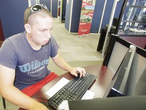 Robert Wall, 18, searches for a job using computers provided by Summer Job Service program at Community Employment Services on Metcalf Street in Woodstock. (HEATHER RIVERS, Sentinel-Review file photo)