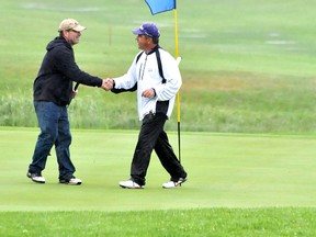 Golfers participating in the Spruce Needles 2013 Men’s Amateur Golf Tournament this past weekend had the best of both works. The sunny conditions on Saturday gave way to constant rain on Sunday. Golfers Robert Vien, left, and Claude Gravel shake hands after completing 18-holes on Sunday. Chris Wilson took top spot in the tournament.