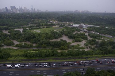 An aerial view of the Don Valley Parkway looking towards Bayview Ave. shows vehicles heading back north in the southbound lanes of the DVP and a GO Train stranded in the distance. A torrential downpour of 106mm over three hours shutdown Toronto on Monday July 8/13 submerging sections of roadways and highwaysand stranding motorists on the Don Valley Parkway. It was the second time in over a month ago that rains have shut down the main artery into the city.   Jack Boland/ Toronto Sun / QMI Agency
