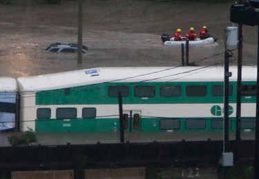 A dingy with emergency personnel on it glides up the submerged Bayview Ave. extension . Emergency officials were trying to get passengers off a stranded GO Train headed towards Richmond Hill that was stuck in the water off the Don Valley River.. A torrential downpour of 106mm over three hours shutdown Toronto on Monday July 8/13 submerging sections of roadways and highwaysand stranding motorists on the Don Valley Parkway. It was the second time in over a month ago that rains have shut down the main artery into the city.   Jack Boland/ Toronto Sun / QMI Agency