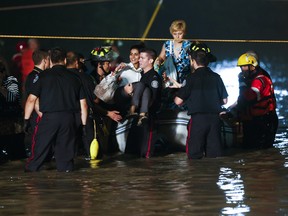 Emergency personnel rescue passengers stranded on a flooded GO Train on Monday night. (ERNEST DOROSZUK, Toronto Sun)