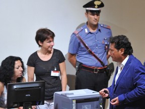 The captain of the ill-fated Costa Concordia cruise ship, Francesco Schettino (R) speaks to court members as he takes place for his trial on July 9, 2013 in Grosseto.  (AFP PHOTO/TIZIANA FABI)