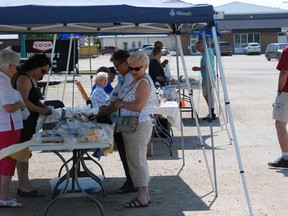 A small crowd gathers early on at the Melfort Farmer’s Market on the first day the market has made it’s way outside in 2013.