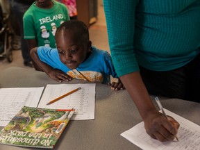 John Ojedokun, 3, looks on as his mother Jane Ojedokun signs him up at the kick-off of the Summer Reading program. The program will be held for youth throughout the summer to promote book reading and continuing education with parents throughout the summer holidays. 
Christopher King | Whitecourt Star