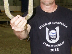 Ken Ruckstuhl, president of the Belleville Horseshoe Club, gets some practice in Tuesday at the Sports Centre. The Canadian championships take place in Rink B from Wednesday through Saturday. (Paul Svoboda/The Intelligencer)