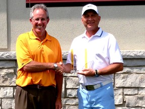 Tony Kameka, right, is presented with the trophy for winning the Huron Oaks/Greenwood Men's Invitational golf tournament by Huron Oaks head pro Cameron Rankin. (Submitted photo)