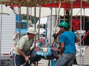 Beauce Carnaval arrived in town overnight on Monday and workers toiled throughout the day to assemble the rides, pavilions and games to ensure that the gates are ready to open this evening. Early Tuesday afternoon, workers turned their attention to the merry-go-round, ensuring that each horse was firmly secured into place before moving on to the next task.