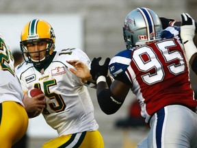 Edmonton Eskimos quarterback Ricky Ray avoids the tackle of Montreal Alouettes defender Moton Hopkins (95) during CFL football action in Montreal, August 11, 2011. (REUTERS/Olivier Jean)