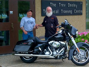 Following an exhausting nine hour drive, Vulcan, Alberta native Les Groves (left) receives the keys from Wally Beasler to his brand new 2013 Harley-Davidson Street Glide FLHX motorcycle courtesy of the Trev Deeley Technical Training Centre and the Harley-Davidson Motorcycle Raffle. (Daniele Alcinii/Fairview Post)