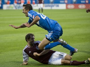 Montreal Impact forward Davy Arnaud is tackled by Colorado Rapids midfielder Brian Mullan during a game at Saputo Stadium on June 29. (QMI Agency)