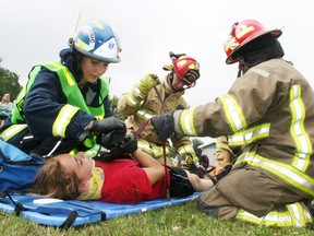 An actor portraying a victim in a simulated chemical plant explosion staged at the Brownsville Community Centre on Wednesday, July 10, 2013, is prepared for transport by firefighters and a paramedic. The mock disaster was organized to give high school students participating in the annual MedQUEST health exploration program a first-hand look at emergency services as the front line health care careers. JOHN TAPLEY/INGERSOLL TIMES/QMI AGENCY
