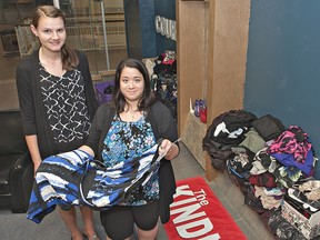 Sarah Yoder (left) of Freedom House Church in Brantford and Christie MacKeigan, assistant manager at Ricki's in Lynden Park Mall are preparing for a clothing sale on Saturday, July 13, 2013 at Market Square.  Employees of Ricki's women's clothing stores decided to donated some of their own gently-used clothing for the sale, which will see all proceeds go to the Canadian Women's Foundation. (BRIAN THOMPSON Brantford Expositor)