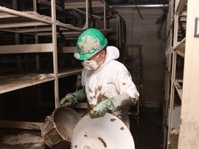 KEVIN RUSHWORTH HIGH RIVER TIMES/QMI AGENCY. A Belfor crew member carries an arm full of artifacts out of the Highwood Memorial Centre basement and up into the light.