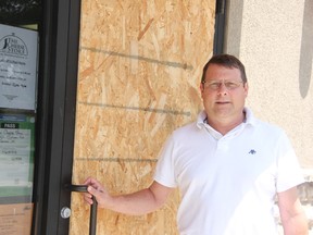 Murray Budden stands next to the smashed and boarded up door at his Point Edward business, The Cheese Store. There was a recent break and enter at The Cheese Store and cash was taken from the register. 
LIZ BERNIER/ THE OBSERVER/ QMI AGENCY