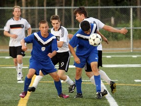 Marc Andre Goulet, left, of the North Bay Selects Jets, and Joey St. Onge (9) of Germania look on as the Jets' Vicente Benitez heads down a loose ball Wednesday night during Nipissing District Adult Soccer League Premier Division action at Steve Omischl Sports Field Complex. Ben Carriere, Mathieu St. Louis, Joey St. Onge, Dan St. Onge, Kevin Clayton and Eric St. Onge scored for Germania in a 6-2 win. James Brunke and Jamie Martyn scored for the Jets.