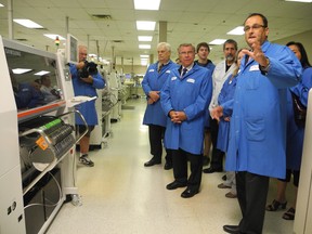 MPIQC president Claude Girard tours MP Guy Lauzon around their manufacturing centre in the city's business park.