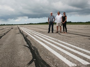 Wiarton-Keppel Airport board chair Dwight Burley, left, airport manager Ken Hamilton of Politiri Aviation Holdings, and operations superviser Melissa Swain stand on the main runway, which is badly in need of repaving. Tracey Richardson photo.