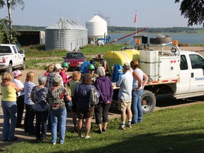 Last year’s tour group gathers around a speaker for a demonstration. - Photo Supplied