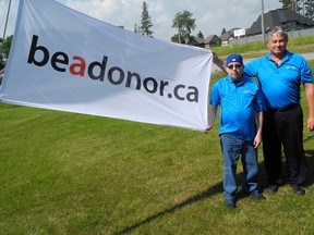 Robert Brush, a recipient of a double lung transplant, and Les Dyjack of RT Respiratory Inc. stand next to the “Be a Donor” flag being flown at RT's Delhi office to encourage local residents to become registered organ donors. (SARAH DOKTOR Delhi News-Record)