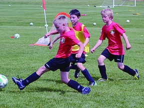 Three soccer players battle for a loose ball. Camp wraps up on Friday, July 12. Steven Wagers/Sherwood Park News/QMI Agency