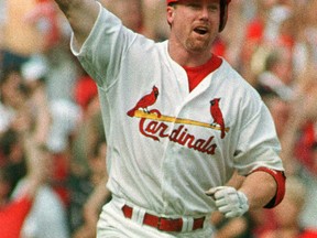 Mark McGwire of the St. Louis Cardinals celebrates breaking Major League Baseball's long-standing single-season home run record on  Sept. 27, 1998. The previous record had stood for decades, while McGwire's was beaten only three years later, by Barry Bonds of the San Francisco Giants. McGwire has admitted using performance-enhancing substances when he broke the record; It has never been proven that Bonds did the same, but both men are associated with baseball's 'Steroid Era.'