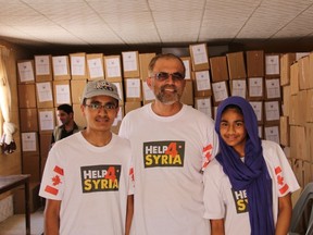 Hamza Khan, left, Mazher Latif and Yusra Latif, all from Brantford, stand with the hundreds of hygiene packs they helped to distribute to Syrian refugees in camps. (Submitted Photo)