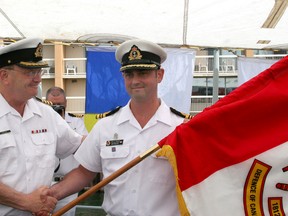 Sen. Hugh Segal presents a banner commemorating the War of 1812 to  Lt.-Cmdr. Paul Roddick, commanding officer of HMCS Kingston.