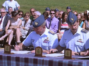 The signing of the scrolls officially marked the change of command at 22 Wing/Canadian Forces Base North Bay Friday morning. From left to right, Col. Sean Boyle, incoming 22 Wing Commander, Maj.-Gen. J.P.S. St-Amand, who presided over the ceremony, and outgoing 22 Wing Commander Col. Conrad Namiesniowski.