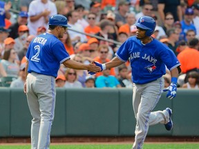 Toronto Blue Jays batter Edwin Encarnacion (R) is greeted by Toronto Blue Jays third base coach Luis Rivera after hitting a home run off of Baltimore Orioles starting pitcher Jason Hammel in the first inning of  their MLB American League baseball game in Baltimore, Maryland July 13, 2013.  (REUTERS)