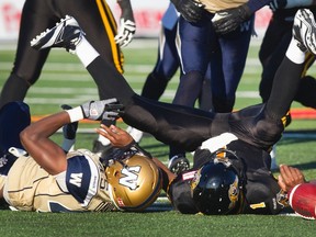 Hamilton Tiger-Cats quarterback Henry Burris is sacked for a loss by Winnipeg Blue Bombers' Dexter Davis in the first half of their CFL football game in Guelph, Ontario July 13, 2013. REUTERS/Fred Thornhill (CANADA - Tags: SPORT FOOTBALL)