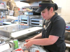 Assistant manager Teng Zafra re-stocks a basket of Tim Horton's new gluten-free coconut macaroons at the 10206-100 Street location on. The tasty treats have been on Grande Prairie shelves since Monday and provide an on-the-go snack option for people with celiac disease or gluten sensitivities. ELIZABETH McSHEFFREY/DAILY HERALD-TRIBUNE/QMI AGENCY