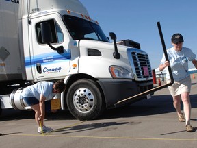 Sharon Loth (left) and Brenda Mason take measurements as Tomasz Kublicki-Piottuch of FedEx competes at the Ontario Truck Driving Championship on Saturday at the Brantford airport. (HUGO RODRIGUES, The Expositor)