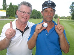 Len Drouillard (left), of Freedom 55 Financial, congratulates Kirk Smith. He won $10,000 when he hit a hole in one at Coors Light Invitational Golf Tournament at Root River Gulf Club on Sunday. Smith's shot came on the seventh hole. It's the first time in 13 years the cash prize was claimed. Drouillard and Matt Inglis, also of Freedom 55, sponsored the award.