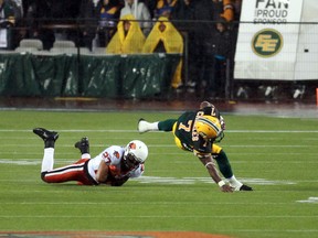 Edmonton Eskimos'  Hugh Charles is tackled by BC Lions' J.R. Larose during a CFL game at Commonwealth Stadium in Edmonton, Alberta on Saturday, July 13, 2013.  Perry Mah/Edmonton Sun/QMI Agency