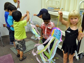 Carley Hauser, 5, right, holds up a jellyfish she created during the "Magic of Books" pre-school program at the Portage la Prairie Regional Library Saturday morning, while other participants watch their jellyfish "float" in the breeze of a fan. (CLARISE KLASSEN/PORTAGE DAILY GRAPHIC/QMI AGENCY)