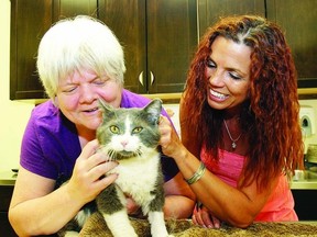 Deborah Perry and Romana Maj, both volunteers with Spay Neuter Kingston Initiative, hug Buster, a recently rescued cat. The group not only helps with the cost of having pets spayed and neutered, but also raises awareness of the importance of preventing unwanted liters.       ROB MOOY - KINGSTON THIS WEEK