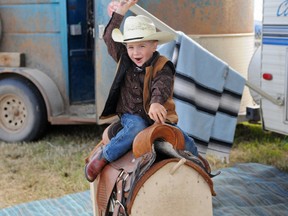 Three-year-old team roper Kyler Korzenowski mounts his steed with a big, "Yeehaw!" at the Teepee Creek Stampede, Saturday July 13, 2013. The Beaverlodge tot  is too young to compete in rodeo now, but promises to round 'em in competitions across Canada once he is old enough. ELIZABETH McSHEFFREY/DAILY HERALD-TRIBUNE/QMI AGENCY