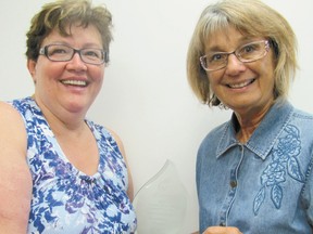 Sylvia Krikun, right, Mayerthorpe finalist for the Alberta Volunteer Citizen of the Year Award presented by The Alberta Weekly newspaper Association and sponsored by Direct Energy, presents her prize of $1,000 to the Margaret Thibault, president of the Fallen Four Memorial Society, for the society on the morning of Thursday, July 11. Thibault nominated Krikun for the award which acknowledges her many volunteer activities in this community.