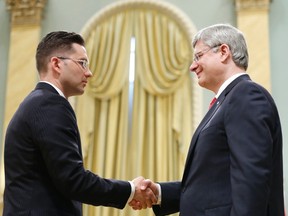 Prime Minister Stephen Harper (R) shakes hands with Minister of State for Democratic Reform Pierre Poilievre after he was sworn in during a ceremony at Rideau Hall in Ottawa July 15, 2013.     
REUTERS/Chris Wattie