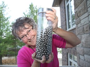 Ruth Debicki, vice-president of the Sudbury Rock and Lapidary Society, holds a jar filled with nickel pellets from Vale. The society is hosting the annual Sudbury Gem and Mineral Show at the Carmichael Arena on July 19-21. The pellets are part of a contest at the show where participants have a chance to win passes to Dynamic Earth if they guess how many pellets are in the jar. JOHN LAPPA/THE SUDBURY STAR/QMI AGENCY