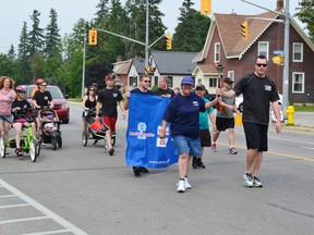 Pictured is Reta McCourt holding the torch with Constable Andy Sachs.