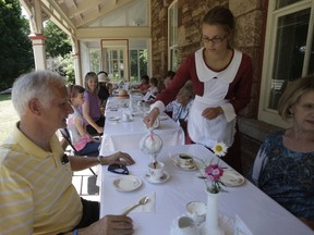 Parks Canada Staffer Carly Wetzl serves tea to Ken Overman during Sunday’s Annual Heritage Tea at the Sault Canal National Historic Site. Overman attended with his wife Gaele at the sold out event. Servers had no problem keeping the tea warm during the extreme heat of the day.