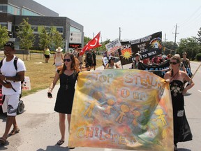 Protestors march away from the target of their outrage, the Family and Children's Services of Frontenac, Lennox and Addington during a rally Tuesday afternoon.
Elliot Ferguson The Whig-Standard