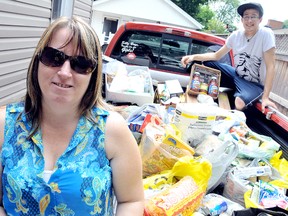Ann Skelton and her son, Kyle, are amazed by the amount of non-perishable goods people donated for her second annual Memorial Food Drive after she put out a plea over Facebook. Skelton decided to make the summer donation to Outreach for Hunger in memory of her father, Russell McGee, who died 10 years ago, and brother Larry McGee who died a year ago Wednesday. Diana Martin/Chatham Daily News/QMI Agency