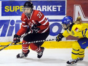 Hayley Wickenheiser of Canada (L) and Frida Nevalainen of Sweden fight for the puck during their Four Nations Cup Ice Hockey game in Finland last November. Local organizers are hoping to bring the tournament, which features Canada, the United States, Finland and Sweden, to Sarnia in 2014. REUTERS FILE PHOTO