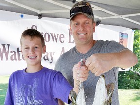 Oshawa anglers Tyler Ward, 13, and his father Bryan Ward, pose with the first catch of the day about 9:30 a.m. Saturday at the weigh-in station of the Crowe Lake Waterway Association's 2013 Pike Only Catch 'em and Keep 'em Fishing Derby.