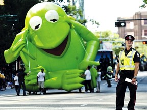 A police officer stands by as Kermit the Frog rolls along during the Capital EX Parade last year. FILE PHOTO QMI Agency