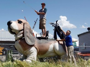 Ryley Jackson makes a shot off the head of Bowser the Cochrane Humane Society’s mascot as he practices for the upcoming tournament while his father Gerry Jackson, chairman of the golf tournament, gives pointers.