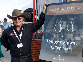 Dennis Weinberger of Cochrane poses besides a picture of he and his horses that hadn’t been beaten in a Pull for five straight years. that is used to promote the Calgary Stampede Heavy Horse Pull.